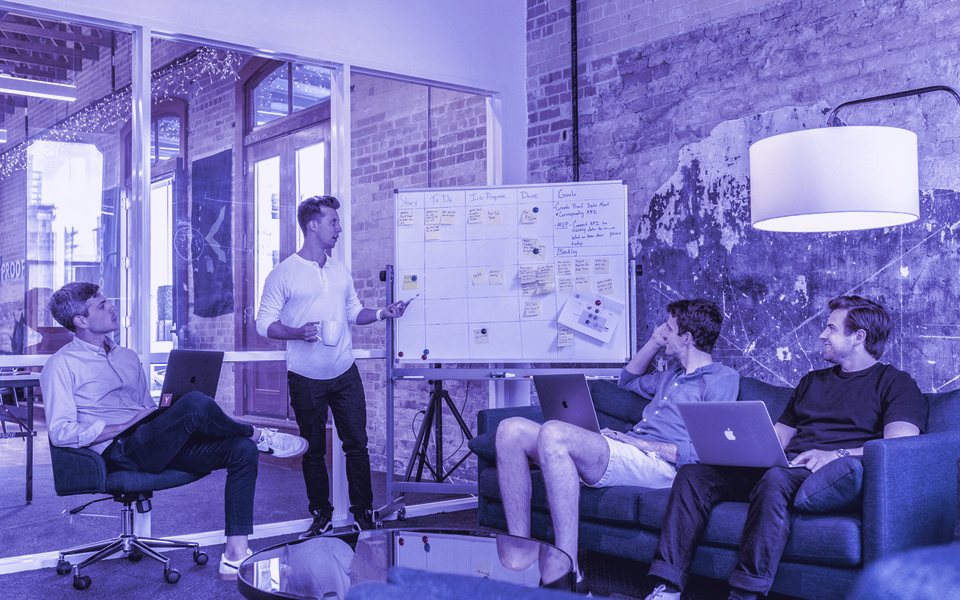 A team discussing a strategy on a whiteboard
